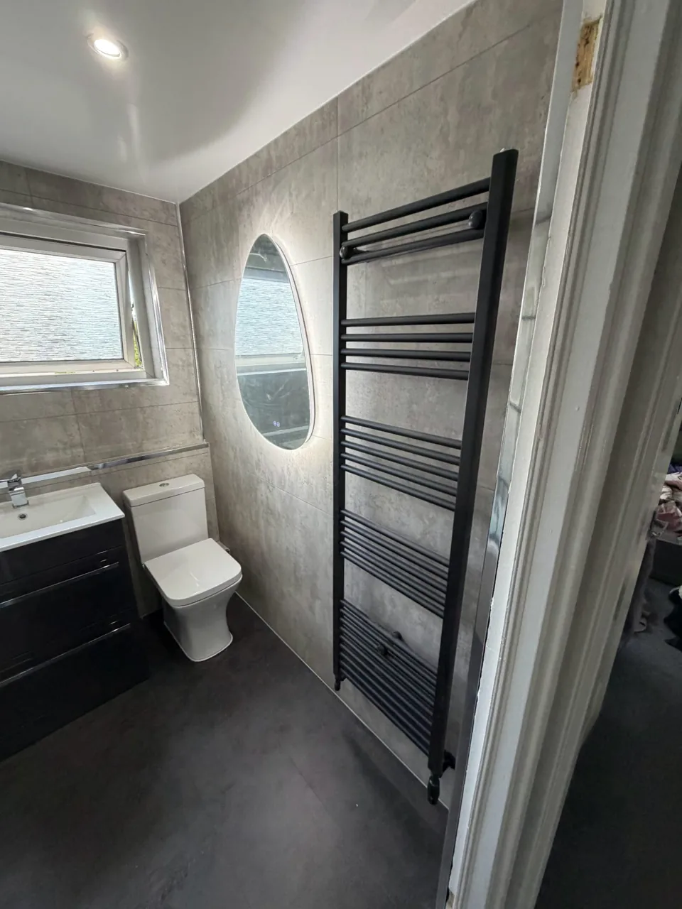 Fitted bath with black shower screen and dark vanity