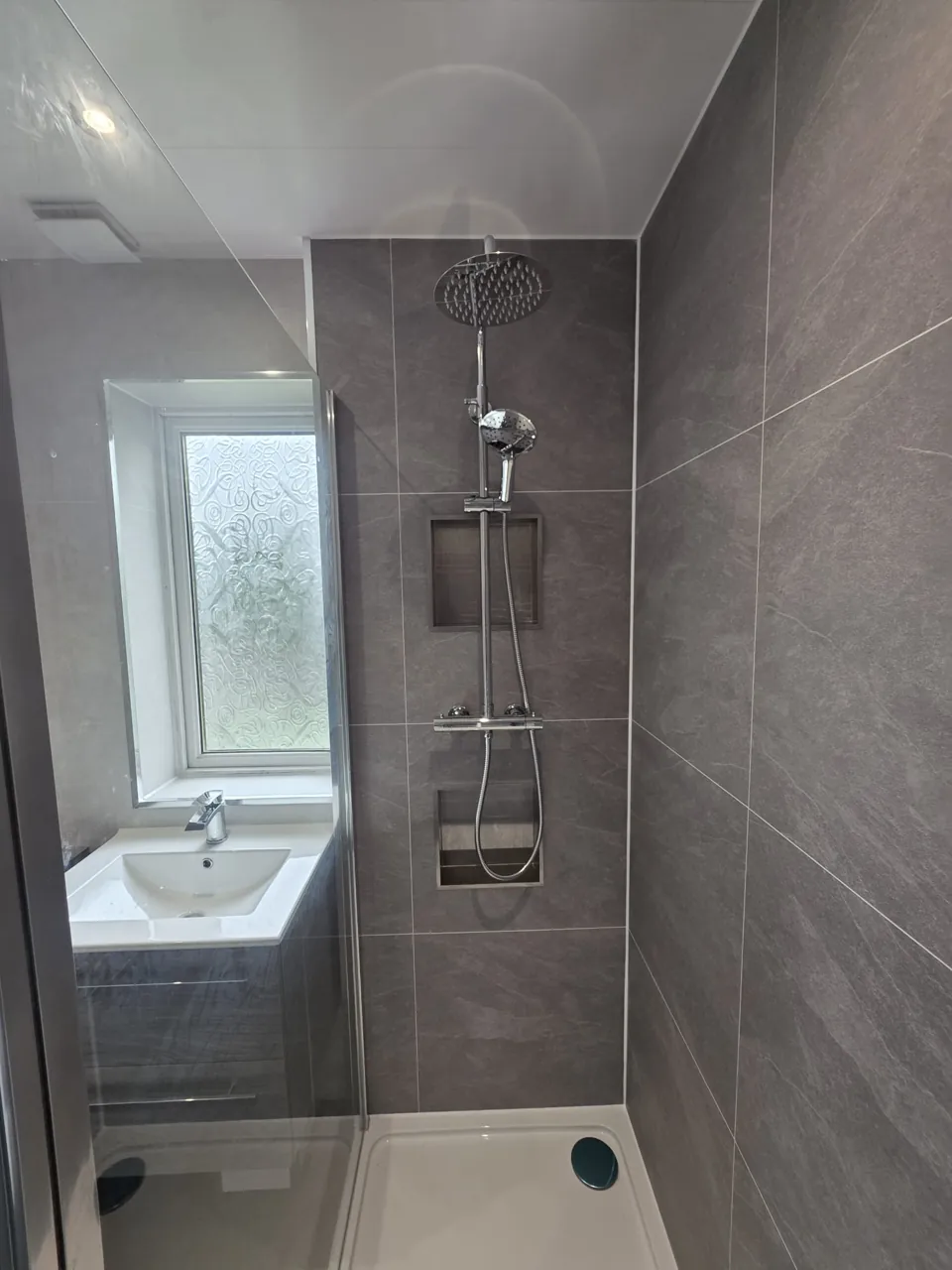 Glass shower screen with recessed wall shelves